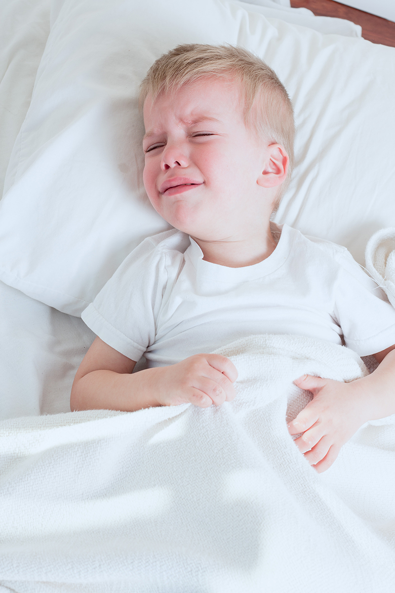 Плачущий мальчик сон. Ребенок плачет. Ребенок болеет. Нарушение сна у детей. Ребенок лежит на кровати.